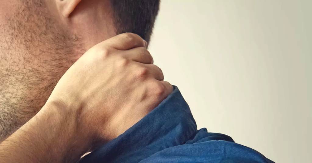 Person rubbing their neck nervously, a subtle sign of deception