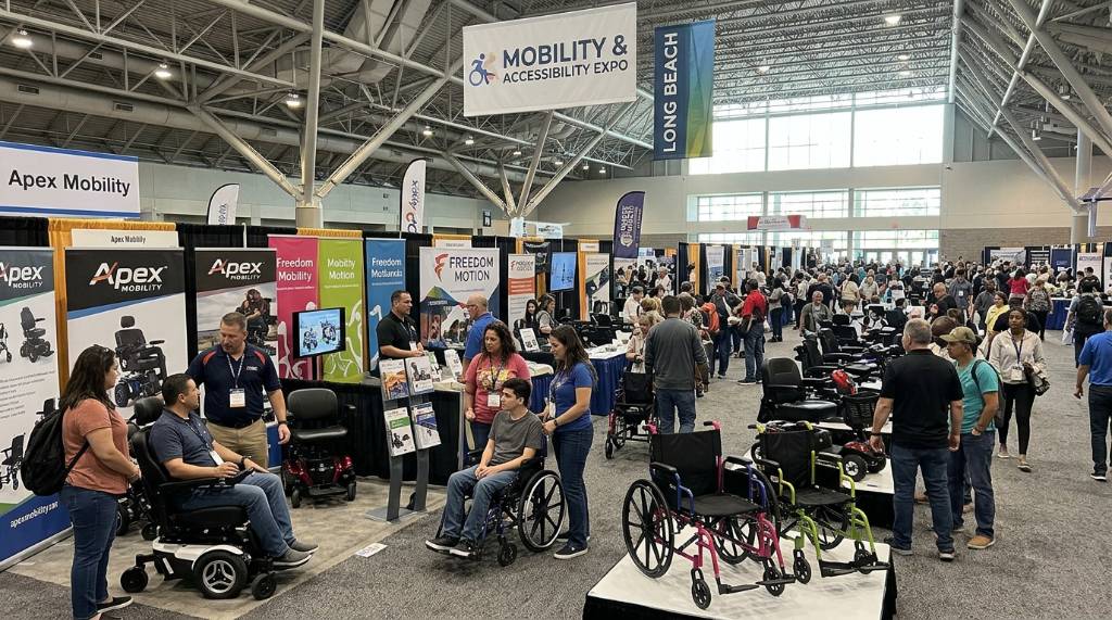 Visitors exploring wheelchairs and mobility products on the show floor at the Long Beach Convention Center